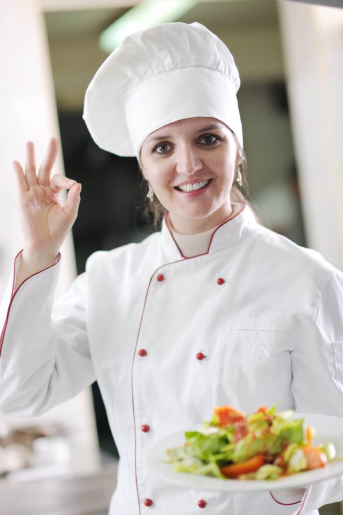 Bella Hartte smiling and giving OK gesture while holding a fresh salad